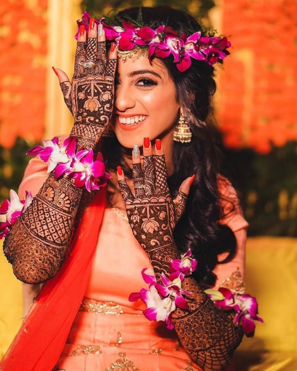 In this image you can see a bride who showing her Mehndi design, this design by on of the best bridal mehndi designer in jhansi, Vijay Mehndi Art & Permanent Tattoo Art